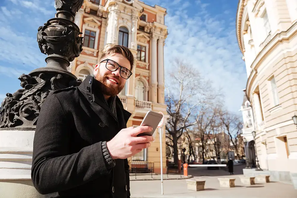 man i frankrike som står med sin telefon